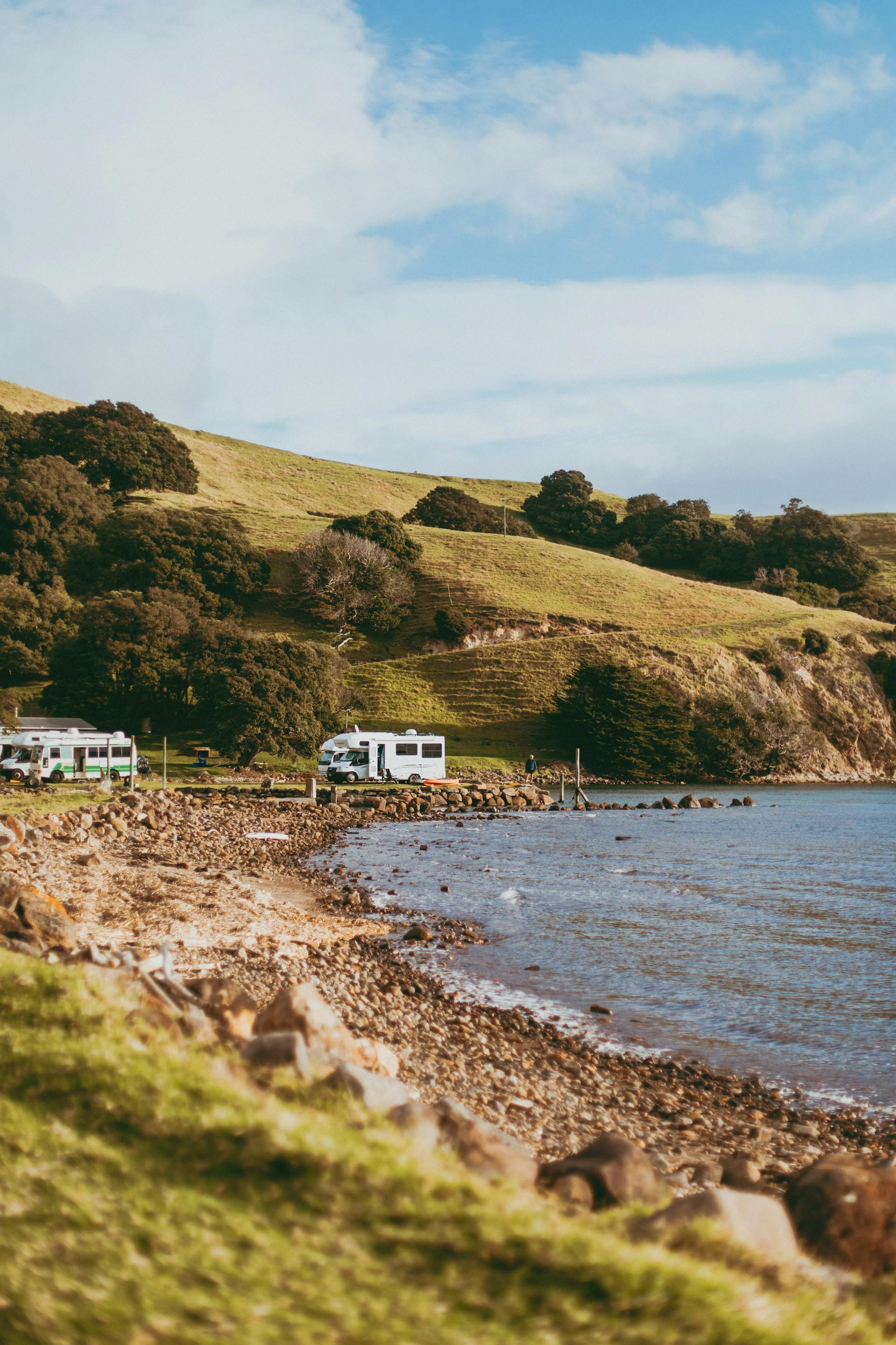 Mobilhomes and campervans parked near a rocky coastline